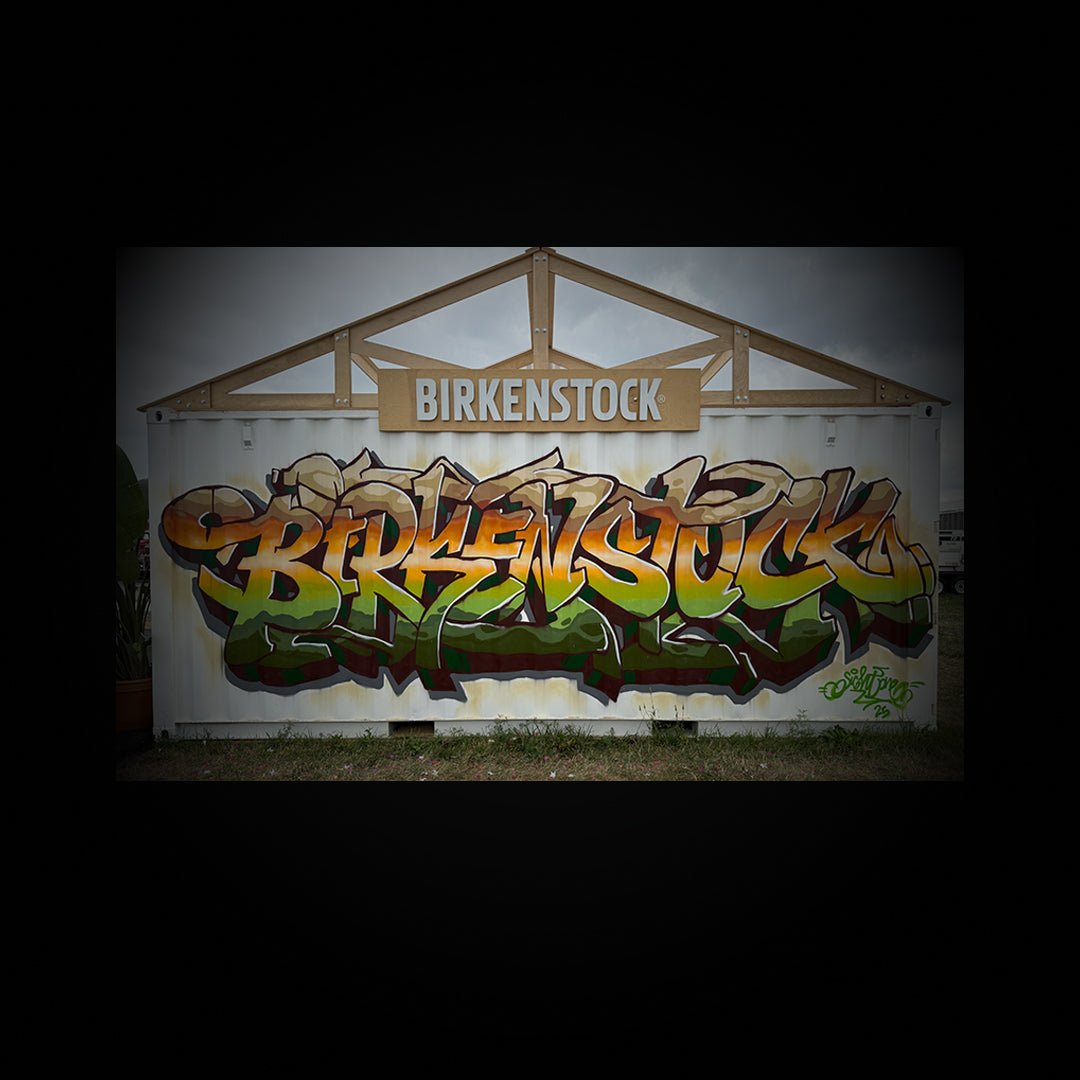 Graffiti on a shipping container with 'Birkenstock' branding.