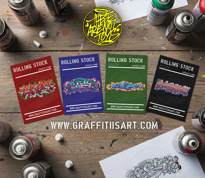 Colorful Rolling Stock cards on a wooden surface with spray paint cans.