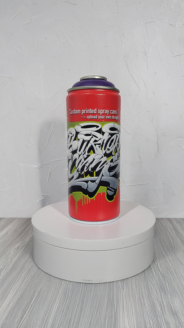 Red spray can with black and white design on a white platform against a textured white background